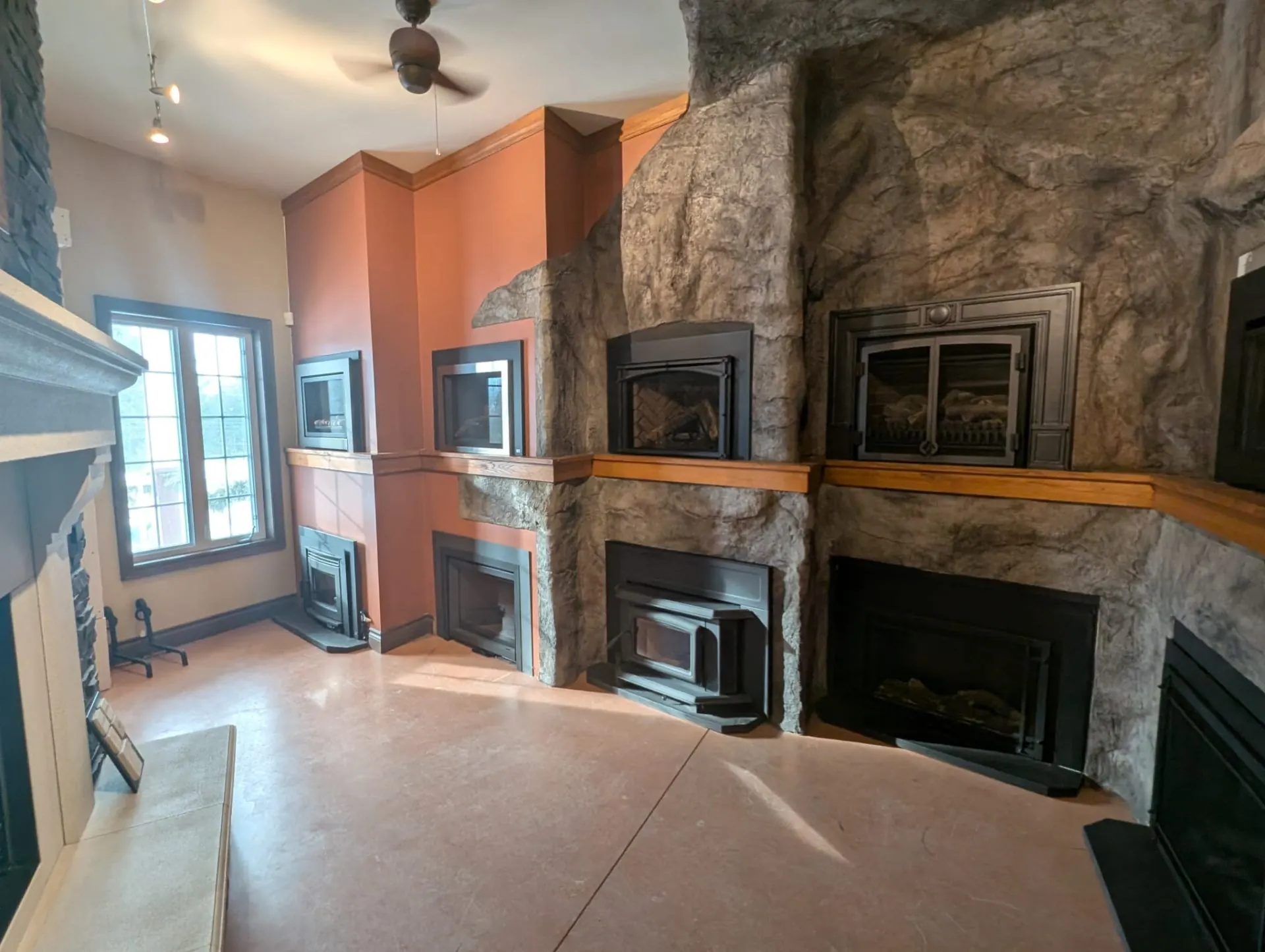Stone cave wall with multiple fireplace inserts on display