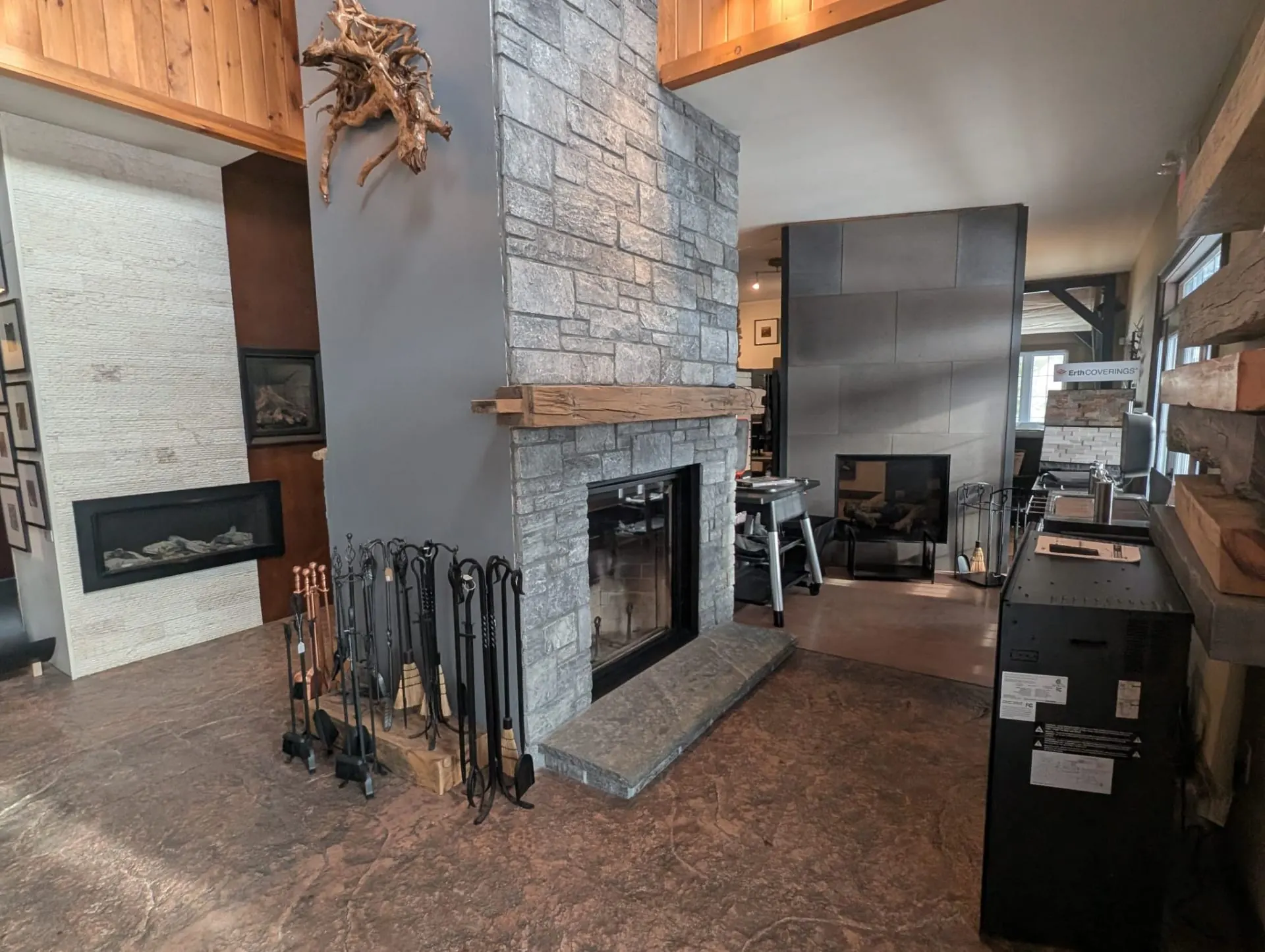 Stone fireplace flanked by hand-forged fire tools